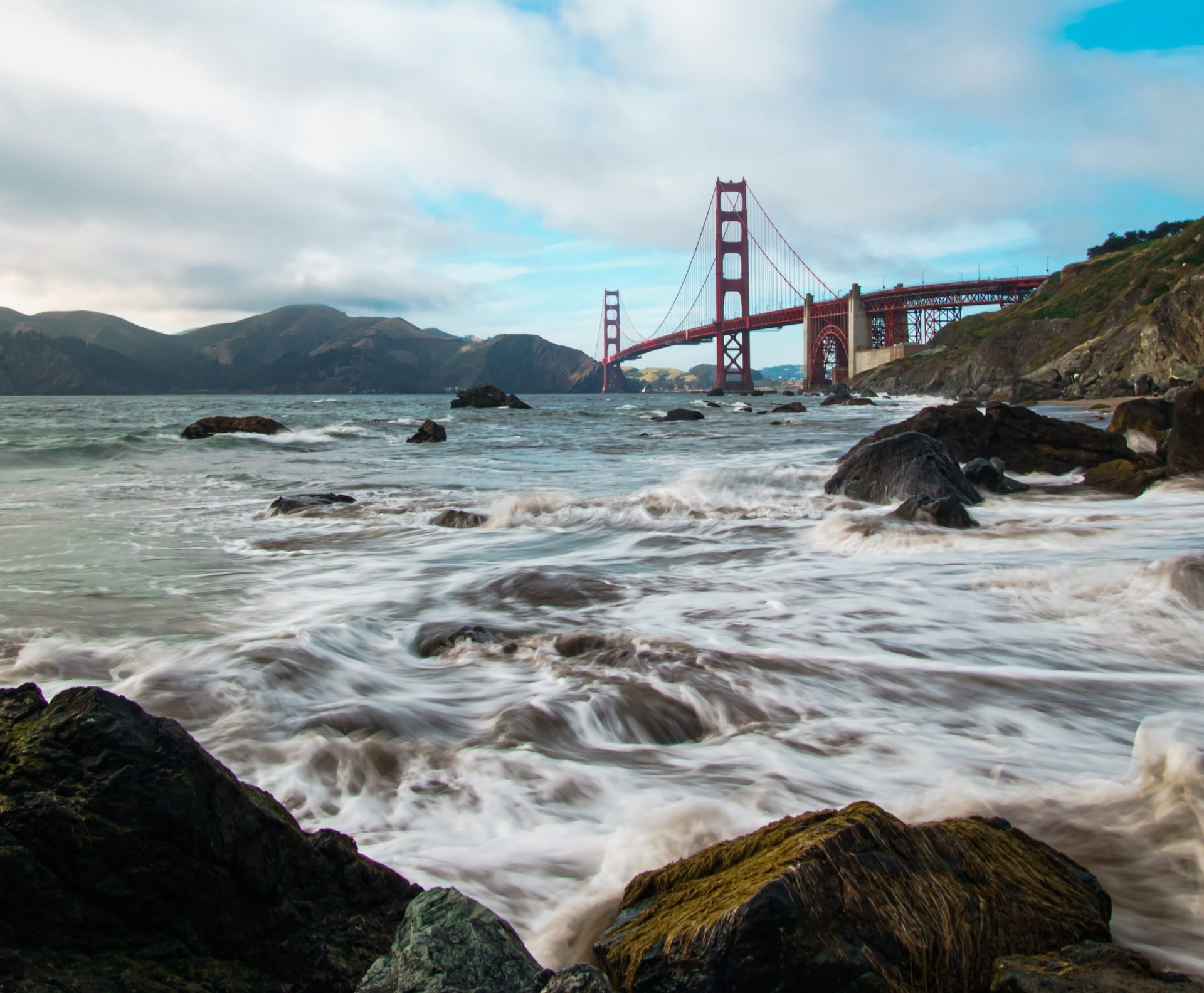 Golden Gate Bridge with a rocky beach in the foreground