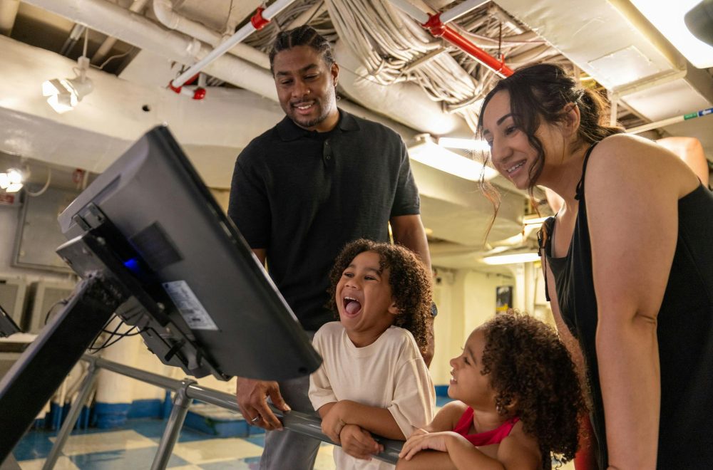 Family interacting with an exhibit at the USS Midway Museum in San Diego