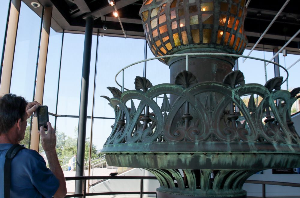 Man taking photo of artifact in Statue of Liberty museum