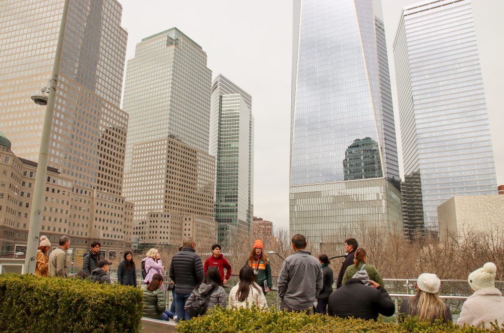 Tour guide and group with skyscrapers during 911 NYC tour