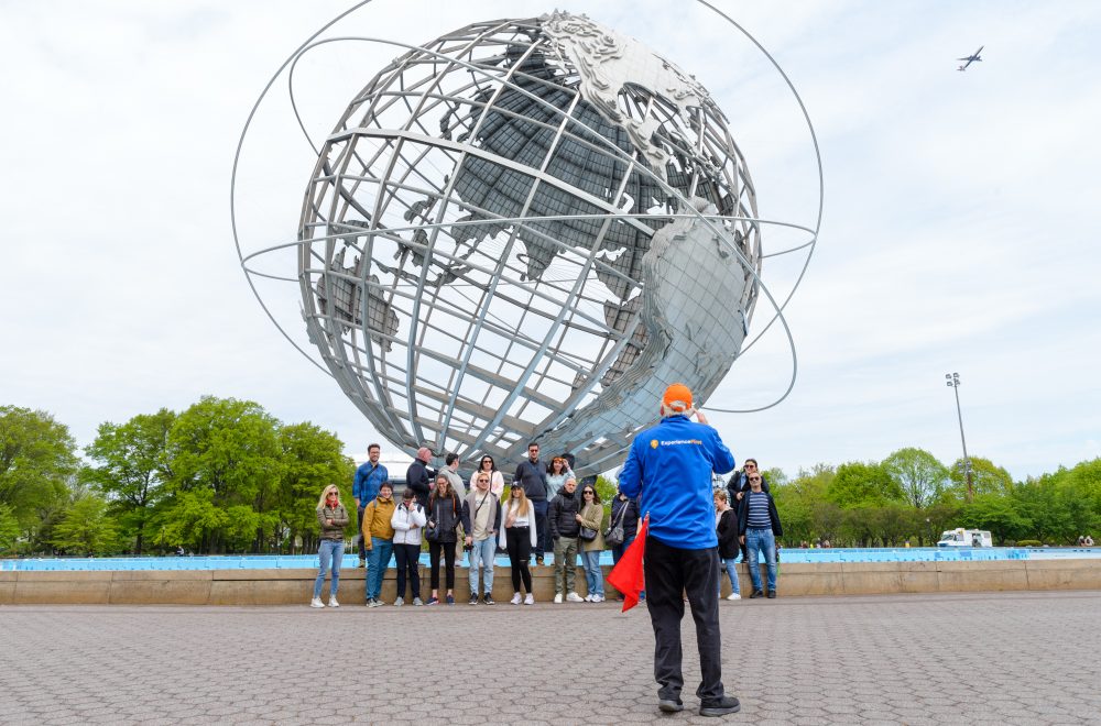 Group shot with guide taking the photo at Unisphere in Brooklyn, Bronx, Queens Tour