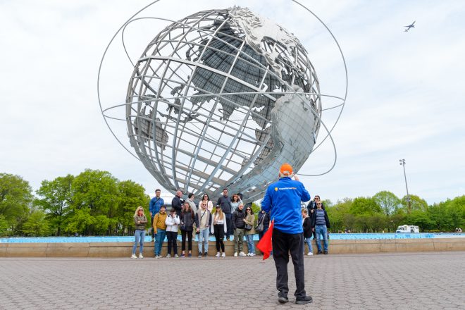 Group shot with guide taking the photo at Unisphere in Brooklyn, Bronx, Queens Tour