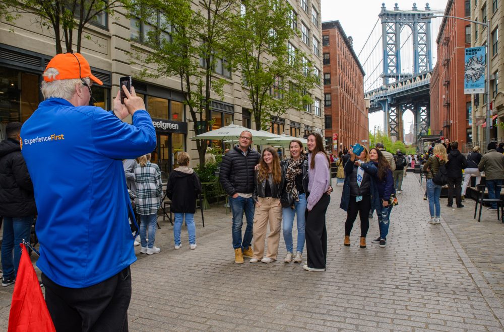 Tour guide taking photo of guests in Brooklyn, Bronx, Queens Bus Tour