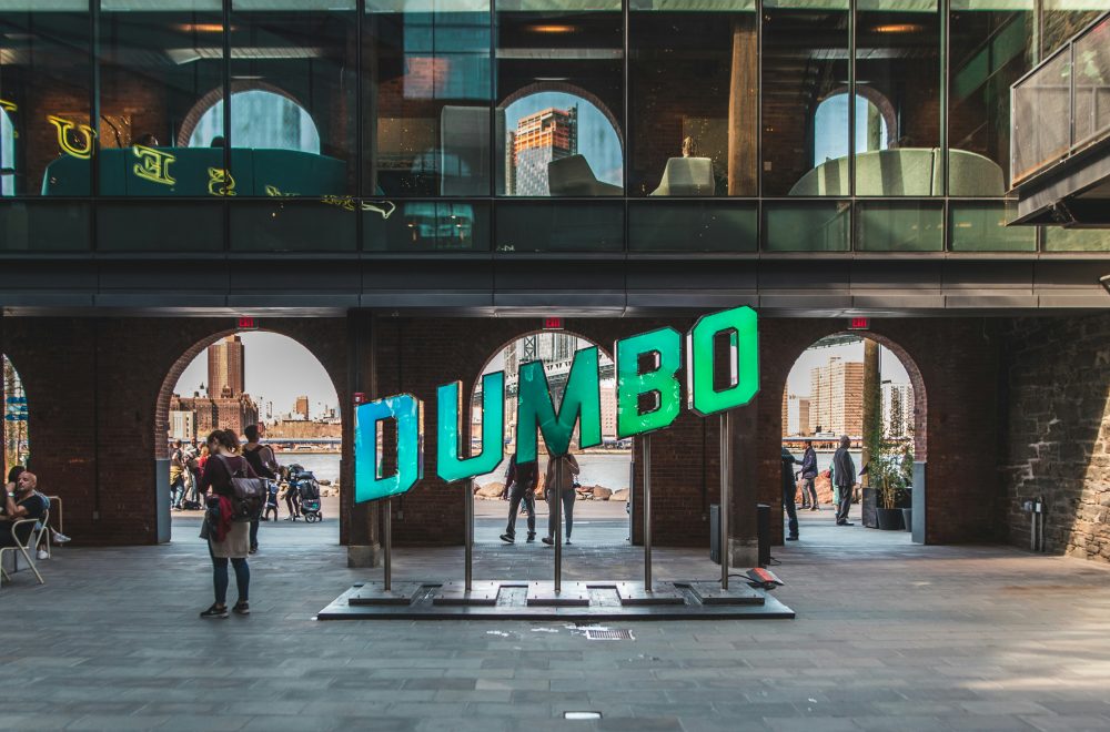 People walking near DUMBO Signage in Brooklyn NYC