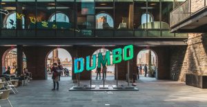 People walking near DUMBO Signage in Brooklyn NYC