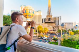 A young man photographs a panorama of the city with the alleys of Las Vegas