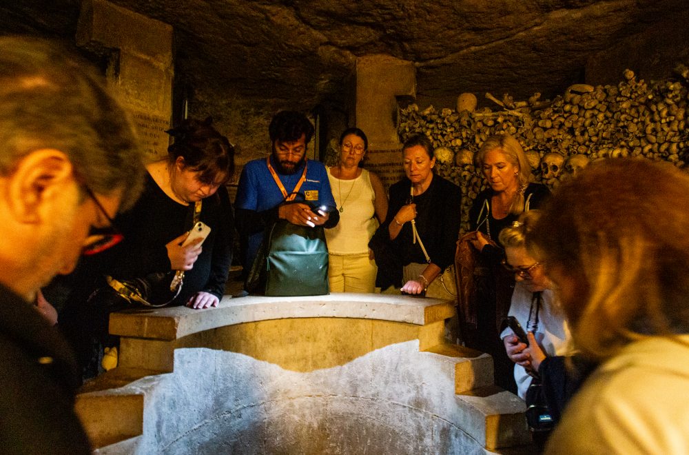 Guide and group looking at tomb during Catacombs Guided Tour