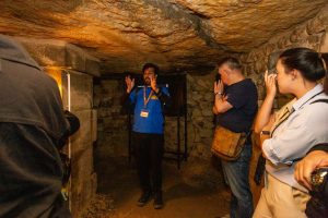 Guide explaining through tombs during Catacombs Guided Tour