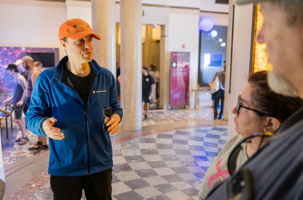 Close up of Tour Guide and guests listening inside Griffith Observatory