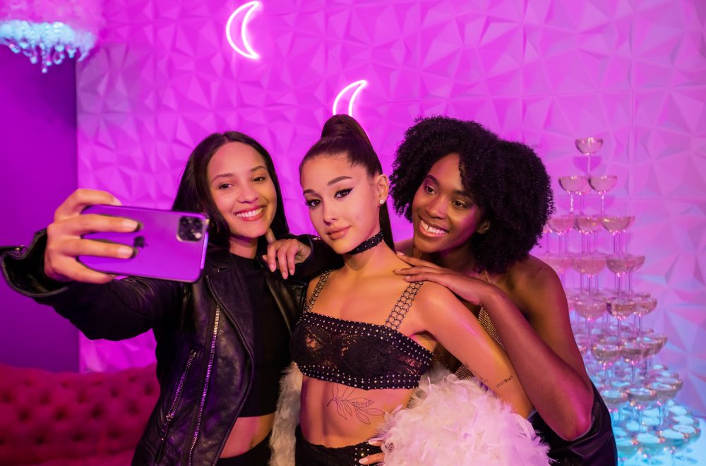 Two visitors taking a selfie with the Madame Tussauds Ariana Grande figure