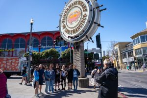 Guide taking group photo during Fisherman_s wharf tour